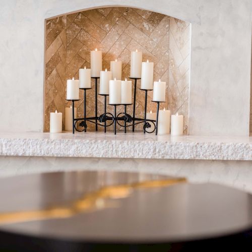 A cake with a chocolate drizzle sits on a table, with a tiered display of pastries in a warm, cozy cafe setting.